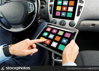 transport, business trip, technology, media and people concept - close up of male hands holding tablet pc computer with menu icons on screen in car