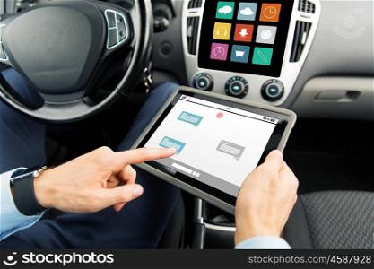 transport, business trip, technology, online communication and people concept - close up of male hands holding tablet pc computer with messenger on screen in car