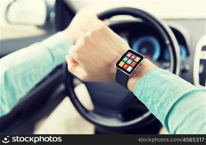 transport, business trip, technology, time and people concept - close up of man with application icons on smartwatch screen driving car