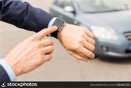 transport, business trip, technology, time and people concept - close up of male hands with wristwatch on car parking