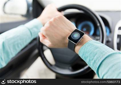 transport, business trip, technology, time and people concept - close up of man with engine start button on smart watch driving car