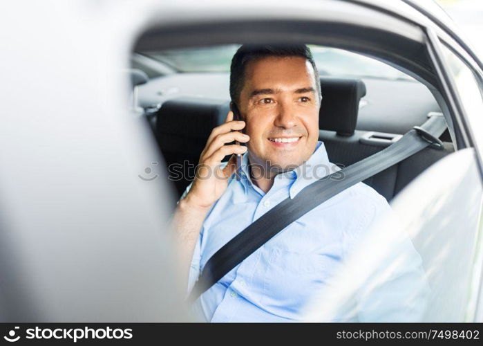 transport, communication and business concept - male passenger or businessman calling on smartphone on back seat of taxi car. male passenger calling on smartphone in taxi car