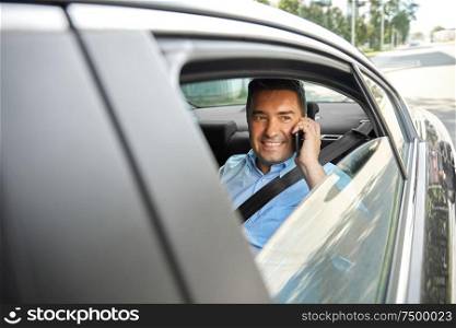 transport, communication and business concept - male passenger or businessman calling on smartphone on back seat of taxi car. male passenger calling on smartphone in taxi car