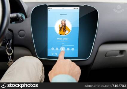 transport, driving, technology, media and people concept - close up of male hand using music player application on car computer