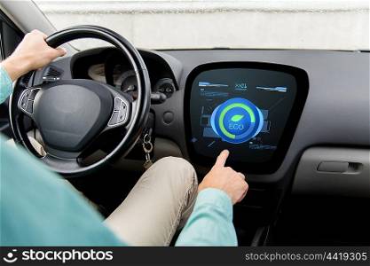transport, green energy, technology and people concept - close up of man driving car and using eco system mode on board computer