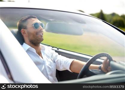 transport, leisure and people concept - happy man in sunglasses driving convertible car. happy man in sunglasses driving convertible car