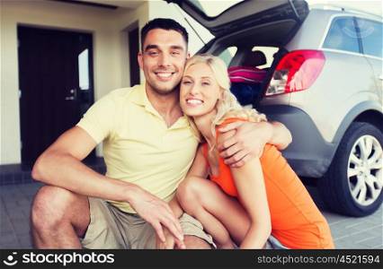 transport, leisure, family and people concept - happy couple hugging at home car parking space