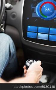 transport, modern technology and people concept - male hand on car gearshift and sound volume level on car audio stereo system