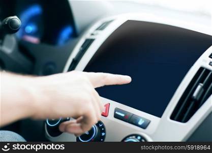 transport, modern technology and people concept - male hand pointing finger to black blank monitor on car panel