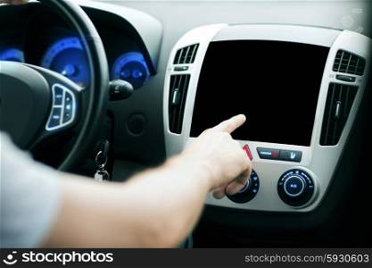 transport, modern technology and people concept - male hand pointing finger to black blank monitor on car panel