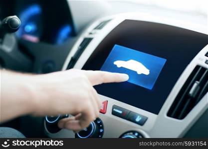 transport, modern technology and people concept - male hand pointing finger to car icon on control panel screen