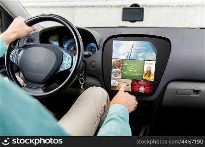 transport, modern technology, media and people concept - close up of man driving car with news on board computer screen