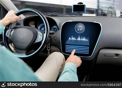 transport, modern technology, music and people concept - close up of man driving car with audio stereo system on board computer