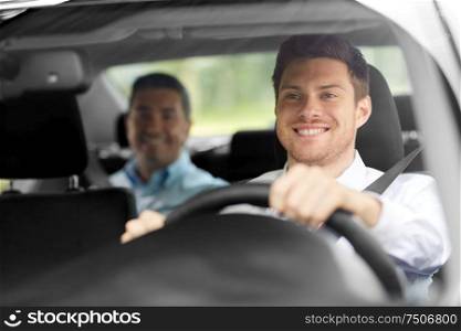 transport, people and taxi concept - happy smiling male driver driving car with passenger. male taxi driver driving car with passenger