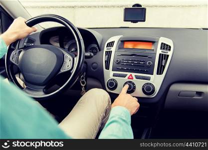 transport, road trip, car driving, technology and people concept - close up of male hand using climate control in car