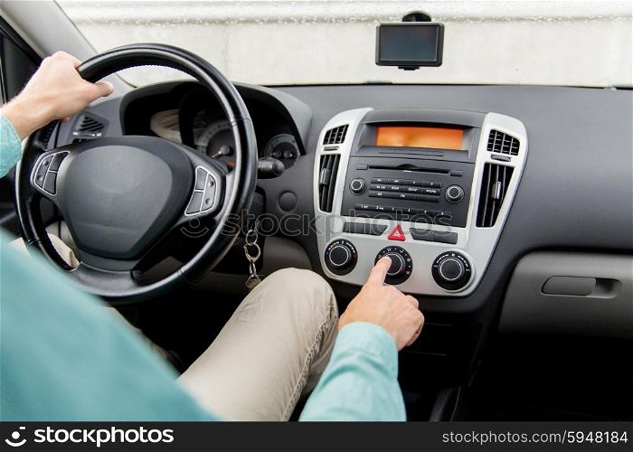 transport, road trip, car driving, technology and people concept - close up of male hand using climate control in car