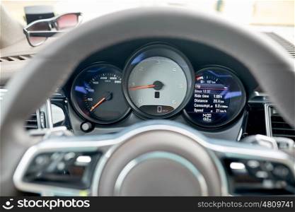 transport, road trip, drive and technology concept - close up of car dashboard with speedometer and tachometer