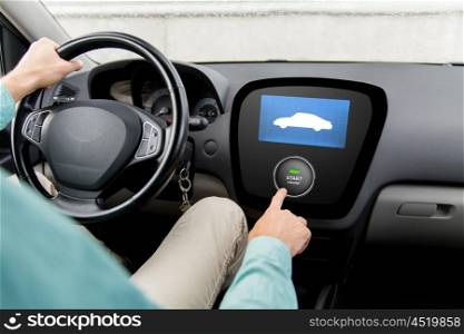transport, road trip, technology and people concept - close up of man driving car and pushing start engine button on board computer