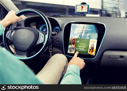 transport, road trip, technology, media and people concept - close up of man driving car and using news application on computer