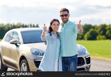 transport, road trip, travel, family and people concept - happy man and woman hugging at car and showing thumbs up