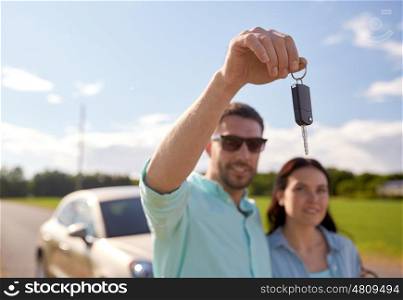 transport, road trip, travel, family and people concept - happy man and woman with car key outdoors