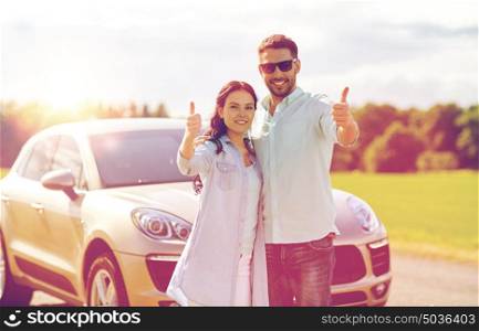 transport, road trip, travel, family and people concept - happy man and woman hugging at car and showing thumbs up . happy man and woman showing thumbs up at car
