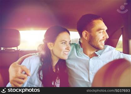 transport, road trip, travel, family and people concept - happy man and woman hugging in car and looking to window . happy man and woman hugging in car