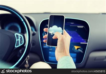 transport, technology and people concept - close up of man driving car and holding smartphone with cloud computing icon on smartphone