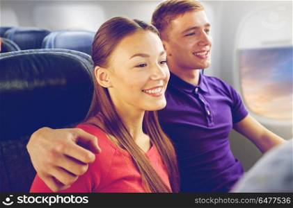 transport, tourism and air flights concept - happy couple travelling by plane over porthole background. happy couple travelling by plane. happy couple travelling by plane