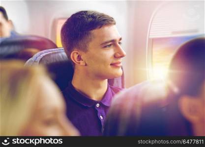 transport, tourism and air flights concept - happy young man travelling by plane over porthole background. happy young man travelling by plane. happy young man travelling by plane