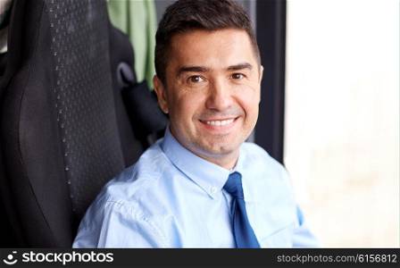 transport, tourism, business trip and people concept - close up of happy bus driver or businessman in shirt and tie
