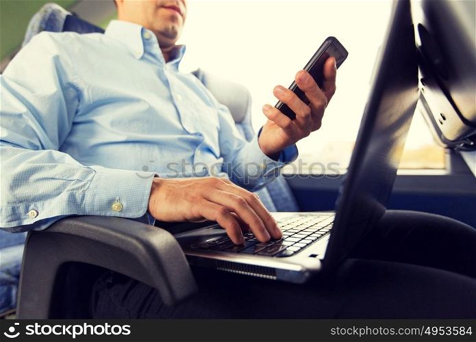 transport, tourism, business trip and people concept - close up of man with smartphone and laptop in travel bus. man with smartphone and laptop in travel bus