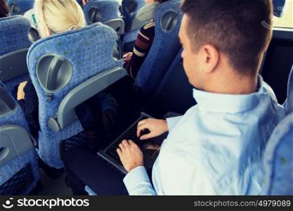 transport, tourism, business trip and people concept - close up of man with laptop typing in travel bus. man with smartphone and laptop in travel bus