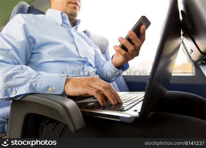 transport, tourism, business trip and people concept - close up of man with smartphone and laptop in travel bus