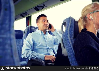 transport, tourism, business trip and people concept - smiling man with smartphone and laptop calling in travel bus. happy man with smartphone and laptop in travel bus