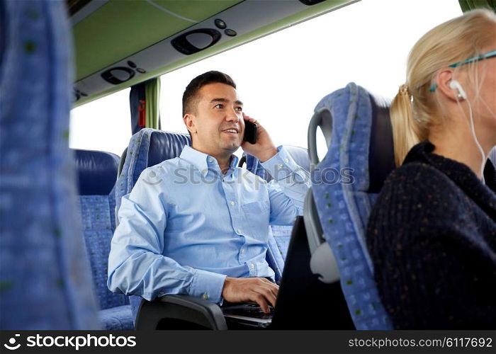 transport, tourism, business trip and people concept - smiling man with smartphone and laptop calling in travel bus