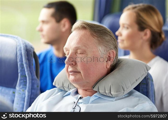 transport, tourism, comfort, road trip and people concept - senior man sleeping in travel bus with neck pillow