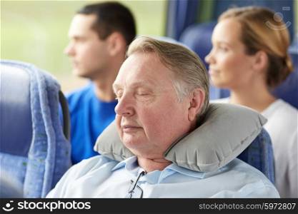transport, tourism, comfort, road trip and people concept - senior man sleeping in travel bus with neck pillow