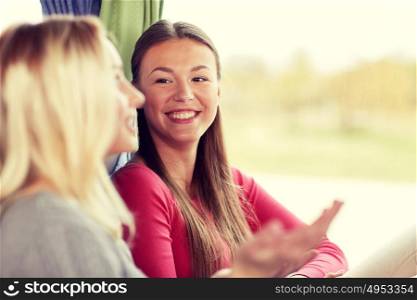 transport, tourism, friendship, road trip and people concept - happy young women sitting and talking in travel bus or train. happy young women talking in travel bus or train