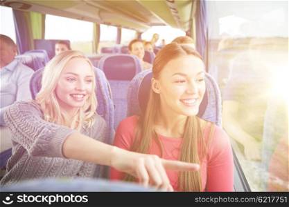 transport, tourism, friendship, road trip and people concept - young women or teenage friends riding in travel bus