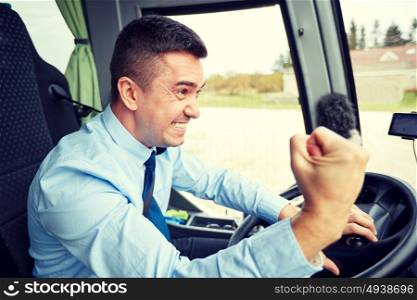 transport, tourism, gesture, emotion and people concept - angry driver showing fist and driving bus. angry driver showing fist and driving bus