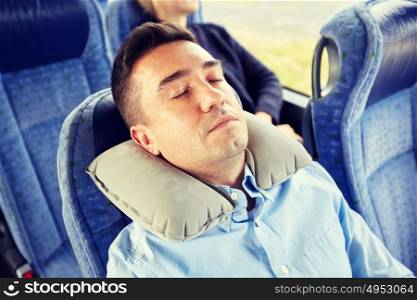 transport, tourism, rest , comfort and people concept - man sleeping in travel bus or train with cervical neck inflatable pillow. man sleeping in travel bus with cervical pillow