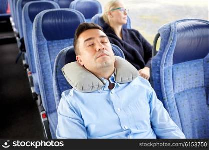 transport, tourism, rest , comfort and people concept - man sleeping in travel bus with cervical neck inflatable pillow