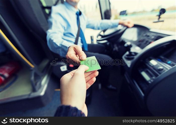 transport, tourism, road trip and people concept - close up of bus driver taking ticket or plastic card from passenger. bus driver taking ticket or card from passenger