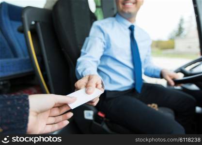 transport, tourism, road trip and people concept - close up of bus driver selling ticket to passenger