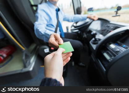 transport, tourism, road trip and people concept - close up of bus driver taking ticket or plastic card from passenger