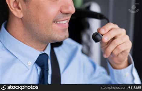 transport, tourism, road trip and people concept - close up of happy bus driver talking to microphone