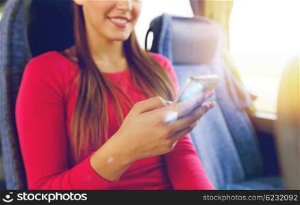 transport, tourism, road trip and people concept - close up of woman in travel bus texting or reading message on smartphone