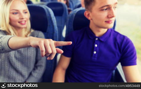 transport, tourism, road trip and people concept - close up of young couple driving in travel bus and pointing finger to something outside. close up of young couple driving in travel bus