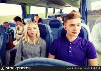 transport, tourism, road trip and people concept - couple with group of passengers or tourists in travel bus. couple or passengers in travel bus